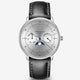 A Sternglas automatic moonphase watch with a silver dial, black leather strap, and blue hands, shown on a light gray background.