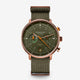 Sternglas London chronograph watch with an olive green dial and matching green canvas strap, featuring a rose gold-toned case and orange accents.