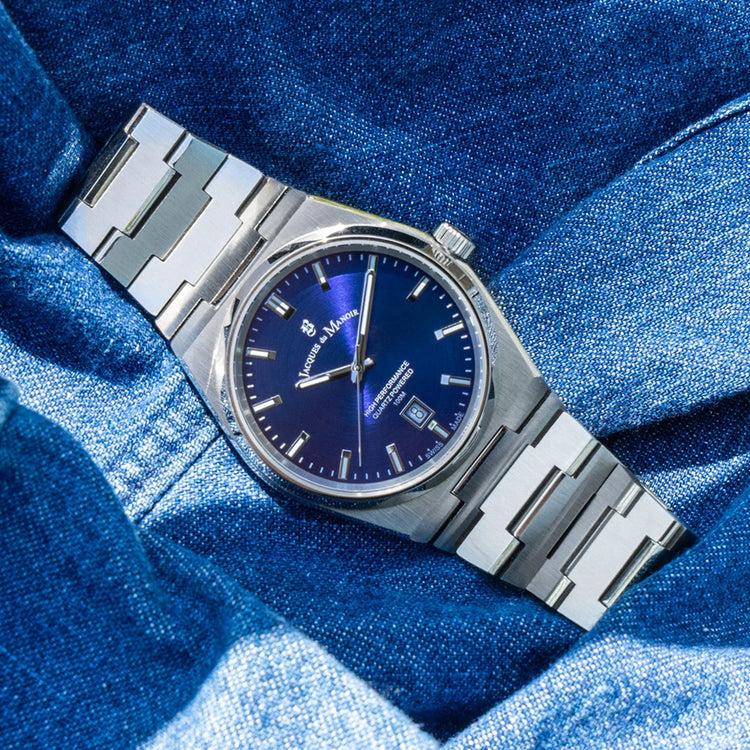 Silver watch with a blue face on a blue textured background