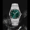 Silver watch with a green dial on a dark background