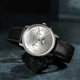 Watch with a brown leather strap on a dark textured surface