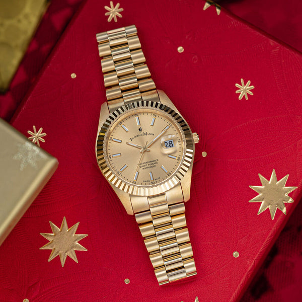 Gold wristwatch on a red fabric background with gold stars