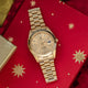 Gold wristwatch on a red fabric background with gold stars