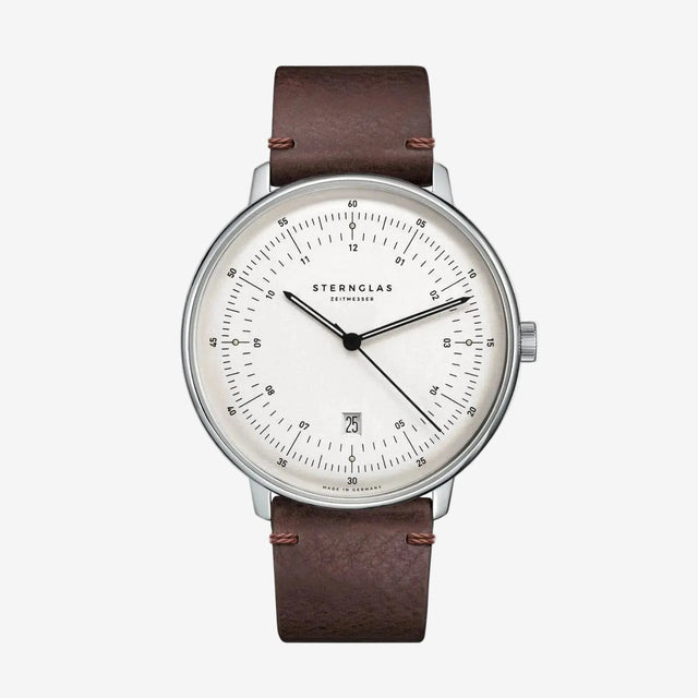 Sternglas watch with a brown leather strap, silver-toned case, and a white dial with black markings and hands, shown against a plain white background.