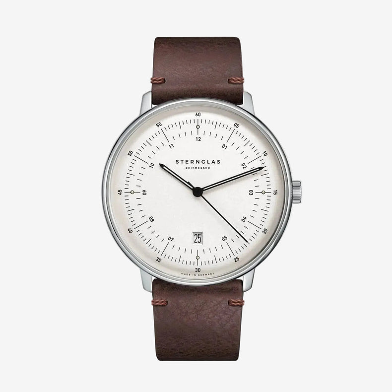 Sternglas watch with a brown leather strap, silver-toned case, and a white dial with black markings and hands, shown against a plain white background.