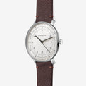 Sternglas by Swatch watch featuring a silver stainless steel case, a clean white dial with black hands and markers, and a textured brown leather strap with visible stitching.